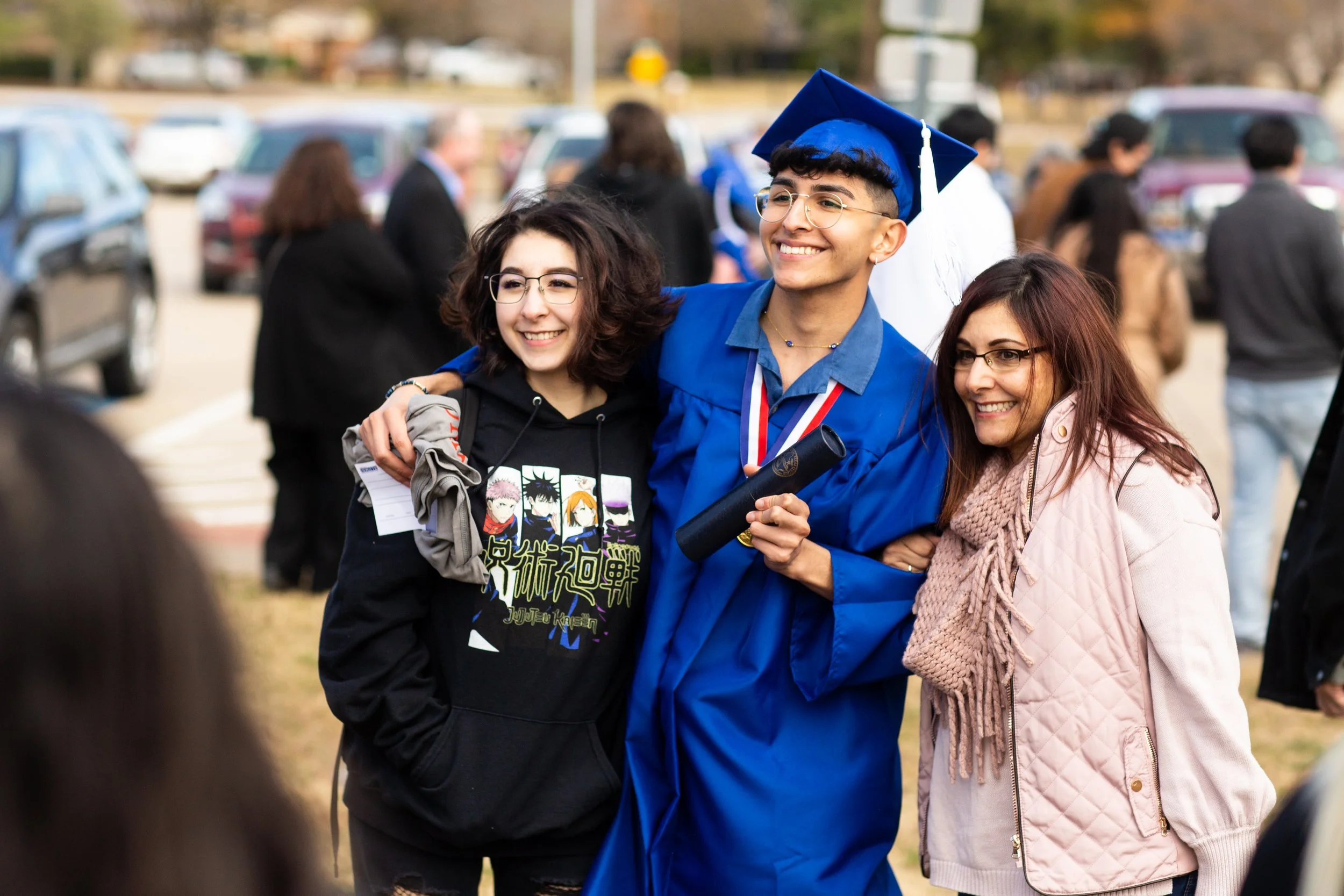 Graduate in cap and gown posing with friends or family